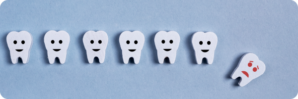 A visual representation of 6 individual teeth in a row with black smiley faces on them and a sixth tooth with a red anxious looking face on it seemingly fallen from the row lying diagonally to show that poor oral hygiene can disrupt the gut microbiome.  
