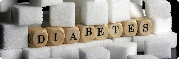 Wooden letters spell out diabetes stacked with sugar cubes.