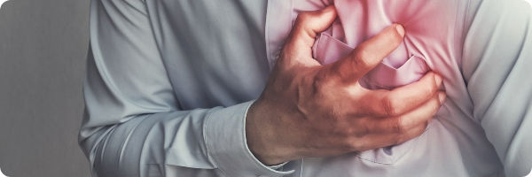 Man clutching his chest as if in pain, chest area is red to signify pain to show heart attack symptoms and heart attack warning signs. 