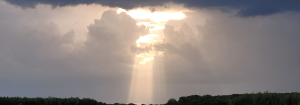 Sunrays breaking through grey clouds to represent the release of stress and tension in the body.