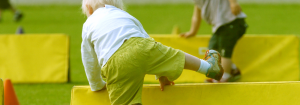 A small child stepping over a yellow barrier to represent that dealing with nicotine cravings and withdrawal means overcoming setbacks.