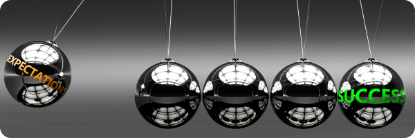 A Newton's cradle with 'Expectation' written on the swinging ball and 'Success' written on the ball on the far side to represent the fact it can be helpful to know what to expect when you stop smoking to help prepare you for dealing with nicotine cravings and withdrawal.