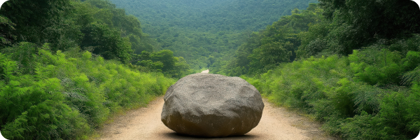 A large rock in the middle of a path that runs between lots of trees to represent how setbacks are usual when someone is trying to stop smoking. 