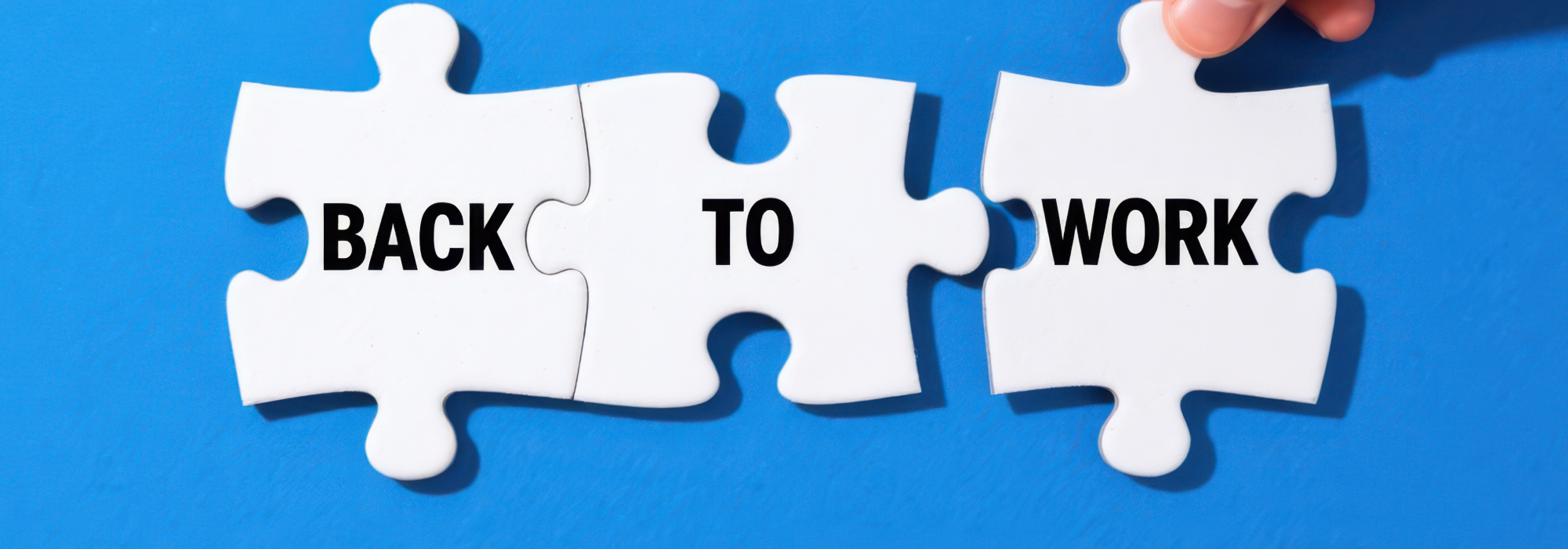 Joined white jigsaw pieces, one with 'Back' and one with 'To' on it on a blue background. A person is joining a piece with 'work' on it to the piece with 'To' on it to represent returning to work with IBS.